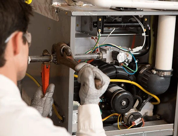 A technician performs AC diagnostic repair on a furnace inside a trailer, ensuring optimal heating system functionality.