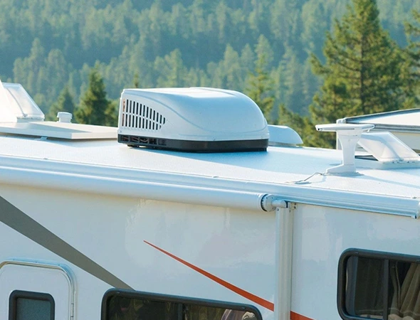A white RV featuring a white roof and air conditioner, illustrating the importance of furnace replacement for optimal comfort.