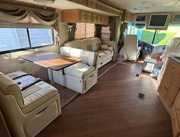 An RV interior showcasing a kitchen, living room, and dining area, highlighting the importance of comprehensive RV repairs.
