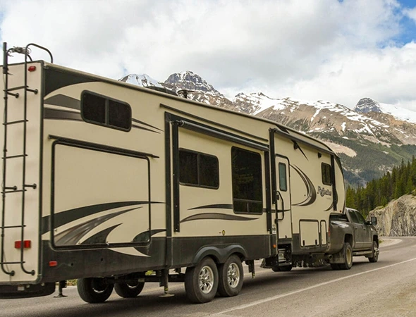 A spacious RV is seen cruising along the road, highlighting its design and the freedom of travel it represents.